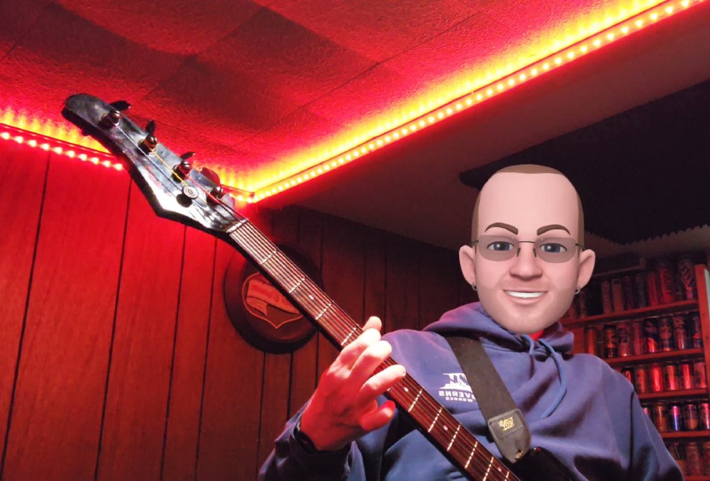 The Other Guy holding a bass guitar.